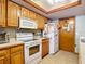 Oak kitchen cabinets and white appliances at 347 Castlewood Ln, New Smyrna Beach, FL 32168