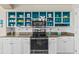 White kitchen cabinets, teal shelving, granite counters, and stainless steel appliances at 3737 S Atlantic Ave # 504, Daytona Beach, FL 32118