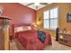 Bedroom with a double bed, red walls, and window shutters at 428 Hightower Dr, Debary, FL 32713