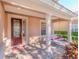 Covered porch with columns, a swing, and a red door at 442 Anessa Rose Loop, Ocoee, FL 34761