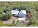 A bird's eye view of a charming house with a light-colored roof, a spacious garage, and a lush green surrounding at 4525 Owls Nest Ct, De Leon Springs, FL 32130
