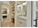 Bathroom vanity with gray countertop, white cabinets, and a decorative mirror at 4525 Owls Nest Ct, De Leon Springs, FL 32130