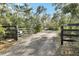 Gated entrance with a gravel driveway leading to the property; showcasing privacy and ample parking at 4525 Owls Nest Ct, De Leon Springs, FL 32130