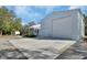 Property showcasing a large metal building, quaint home, and expansive concrete parking area at 4525 Owls Nest Ct, De Leon Springs, FL 32130