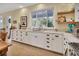 Bright kitchen with white cabinets, granite countertops, and a large window overlooking the backyard at 4525 Owls Nest Ct, De Leon Springs, FL 32130