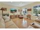 Comfortable living room with stylish furniture, a mounted TV, and a large window overlooking the beautiful outdoors at 4525 Owls Nest Ct, De Leon Springs, FL 32130