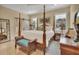 Main bedroom features a four-poster bed, dresser, bench, and natural light at 4525 Owls Nest Ct, De Leon Springs, FL 32130