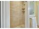 Tiled shower with glass door, rainfall shower head, and pebble floor design at 4525 Owls Nest Ct, De Leon Springs, FL 32130
