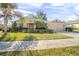 Single-story home with landscaped yard, attached garage, and palm trees at 555 Morgan Wood Dr, Deland, FL 32724