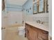 Traditional bathroom with white tile, blue walls, decorative anchors, and a wooden vanity at 641 Hartley Ave, Deltona, FL 32725
