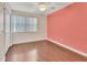 Bedroom with a pink accent wall, ceiling fan and laminate wood flooring at 641 Hartley Ave, Deltona, FL 32725
