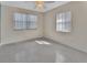 Bright bedroom featuring neutral walls, tiled floor, ceiling fan, and natural light from two windows at 641 Hartley Ave, Deltona, FL 32725