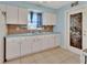Traditional kitchen featuring tile floors, blue walls, and white cabinets with a stained glass door at 641 Hartley Ave, Deltona, FL 32725