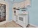 Traditional kitchen with light blue walls, built-in microwave shelving, and a white electric oven at 641 Hartley Ave, Deltona, FL 32725