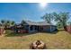 Beautiful backyard with a screened-in pool, hot tub, fire pit, and lush lawn at 709 Lone Oak Dr, Port Orange, FL 32127