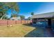 View of the backyard featuring a wooden fence, fire pit, lawn and a screened in porch with a pool at 709 Lone Oak Dr, Port Orange, FL 32127