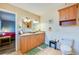 Well-lit bathroom with double vanity, wood cabinets, and beige tile floor at 709 Lone Oak Dr, Port Orange, FL 32127