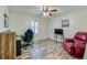 Bedroom featuring wood-look floors, a ceiling fan, and a comfortable workspace by the window at 709 Lone Oak Dr, Port Orange, FL 32127