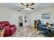 Bedroom features wood-look floors, a ceiling fan, comfortable seating, and a workspace at 709 Lone Oak Dr, Port Orange, FL 32127