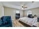 Cozy bedroom featuring wood-look floors, ceiling fan, comfortable bed, and a window with blinds at 709 Lone Oak Dr, Port Orange, FL 32127