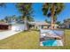 Charming single-story home with a two-car garage, well-manicured lawn, and screened-in pool area visible in the foreground at 709 Lone Oak Dr, Port Orange, FL 32127