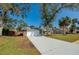 Wide shot of a single-story home featuring a long driveway leading to a two-car garage and mature trees in the front yard at 709 Lone Oak Dr, Port Orange, FL 32127