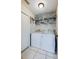 Functional laundry area with a washer, dryer, storage shelves, and tiled floor at 709 Lone Oak Dr, Port Orange, FL 32127