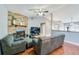 Living area showcasing hardwood floors, a brick fireplace, and an open layout with a partial view of the kitchen at 709 Lone Oak Dr, Port Orange, FL 32127