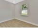 Bright bedroom with wood-look floors and a window offering backyard views at 731 E Cox St, Deland, FL 32724