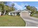 Newly constructed home with a light green exterior, two-car garage, and manicured lawn at 731 E Cox St, Deland, FL 32724