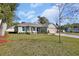 Newly built home showcasing a light green exterior, landscaping, and a spacious front yard at 731 E Cox St, Deland, FL 32724