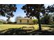 Spacious backyard featuring grass, landscaping, bench and the house at 101 Los Arbor Dr, Deland, FL 32724