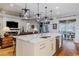 Modern kitchen island with white cabinets and quartz countertops, open to living area at 1137 Avery Meadows Way, Deland, FL 32724