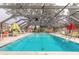 Community pool with screened enclosure and seating at 1260 Charter Oaks Cir, Daytona Beach, FL 32117