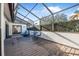 Spacious screened patio with wood deck, table and chairs, offering an outdoor entertaining area at 129 Oyster Catcher Ct, Daytona Beach, FL 32119