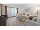 Spacious living room with light colored sofas and wood-look floors at 1420 N Atlantic Ave # 1102, Daytona Beach, FL 32118
