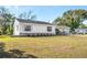 Newly renovated house exterior boasts a fresh coat of white paint and a landscaped lawn at 1612 Beatrice Dr, Orlando, FL 32810