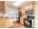 Kitchen with wood cabinets, black appliances, and tiled floor at 1668 Spring Garden Ct # 1668, Daytona Beach, FL 32117