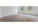 Well-lit bedroom showcasing two large windows and neutral-colored carpet at 1870 S Lehigh Dr, Deltona, FL 32738