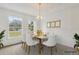Bright dining room featuring a modern chandelier, white chairs, and sunlight from the window at 1870 S Lehigh Dr, Deltona, FL 32738