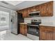 Well-lit kitchen featuring stainless steel appliances and wood cabinetry at 1870 S Lehigh Dr, Deltona, FL 32738