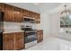 Bright kitchen features white tile floors, wood cabinets, and stainless steel appliances at 1870 S Lehigh Dr, Deltona, FL 32738