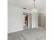 Bright living room featuring neutral walls, gray carpet, and a decorative light fixture at 1870 S Lehigh Dr, Deltona, FL 32738