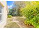 A winding walkway through the manicured backyard, surrounded by mature landscaping at 1930 Seclusion Dr, Port Orange, FL 32128