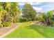 Lush backyard featuring green grass and tropical landscaping at 1930 Seclusion Dr, Port Orange, FL 32128