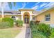 Elegant entryway with a decorative glass door surrounded by columns and manicured landscaping at 1930 Seclusion Dr, Port Orange, FL 32128