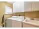 Functional laundry room with washer, dryer, utility sink, and ample storage cabinets at 1930 Seclusion Dr, Port Orange, FL 32128