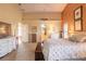 Bright main bedroom with floral bedding, a cozy bench, and access to a lovely ensuite bathroom at 1930 Seclusion Dr, Port Orange, FL 32128