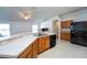 Kitchen features an island, wood cabinets, and black appliances at 2370 Alton Rd, Deltona, FL 32738