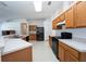 Kitchen offers ample counter space, wood cabinets, and black appliances at 2370 Alton Rd, Deltona, FL 32738